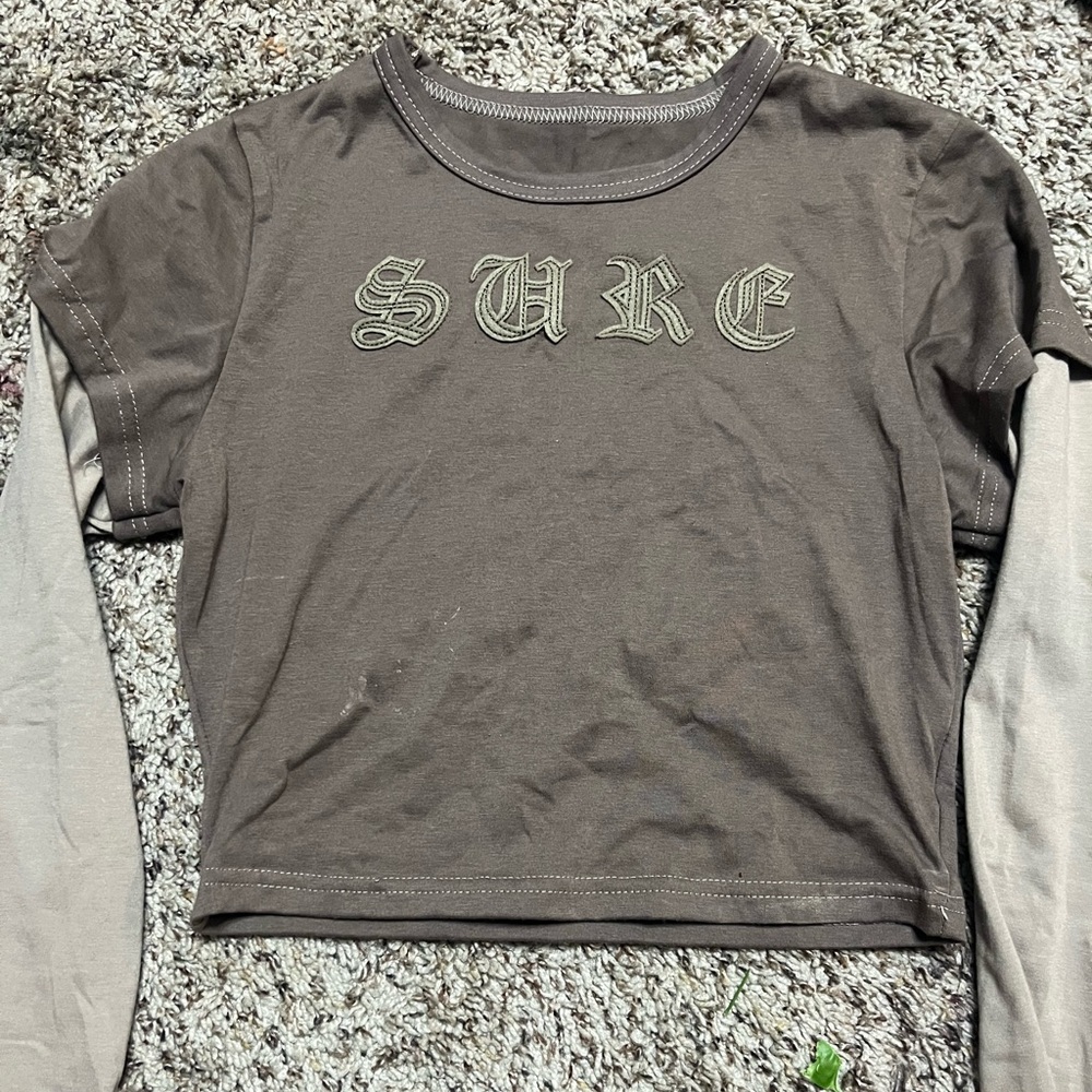 Long sleeve brown and tan tee with writing on the front